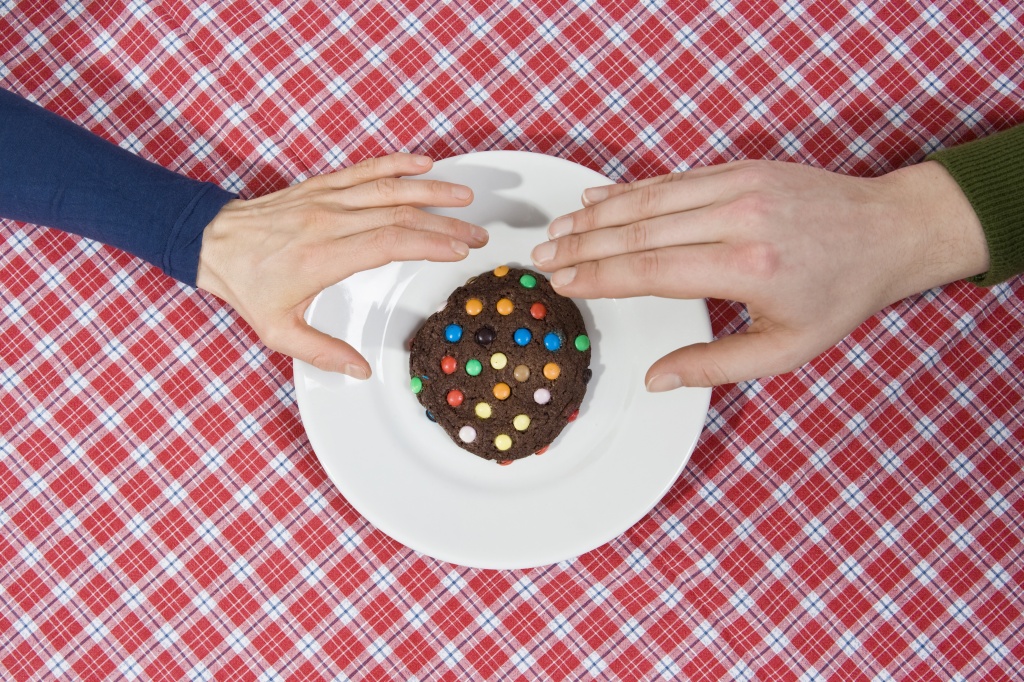 Two hands reaching for a cookie