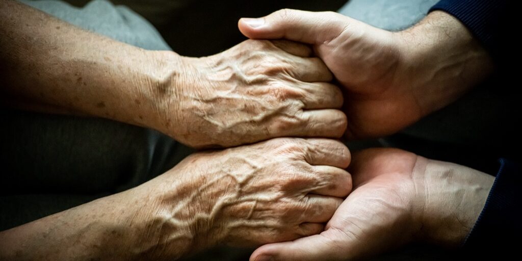 Close up of son holding his mothers hands